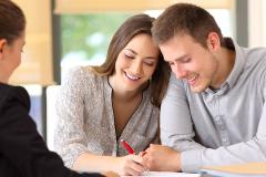 Jeune couple signant un compromis de vente