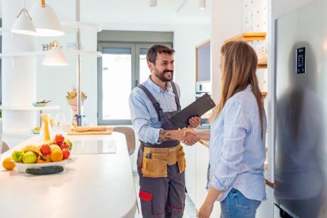 artisan concluant un accord avec sa cliente dans sa cuisine