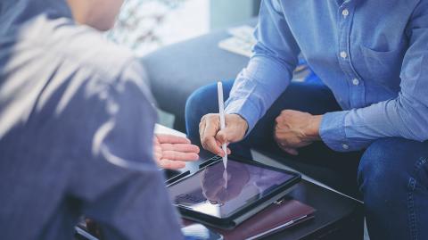 Hommes en train de signer un contrat sur tablette