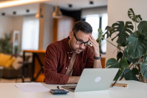 Un homme, devant son ordinateur, concentré