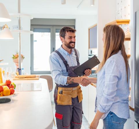 artisan concluant un accord avec sa cliente dans sa cuisine