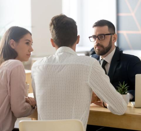 un homme et une femme devant le notaire signent un compromis de vente